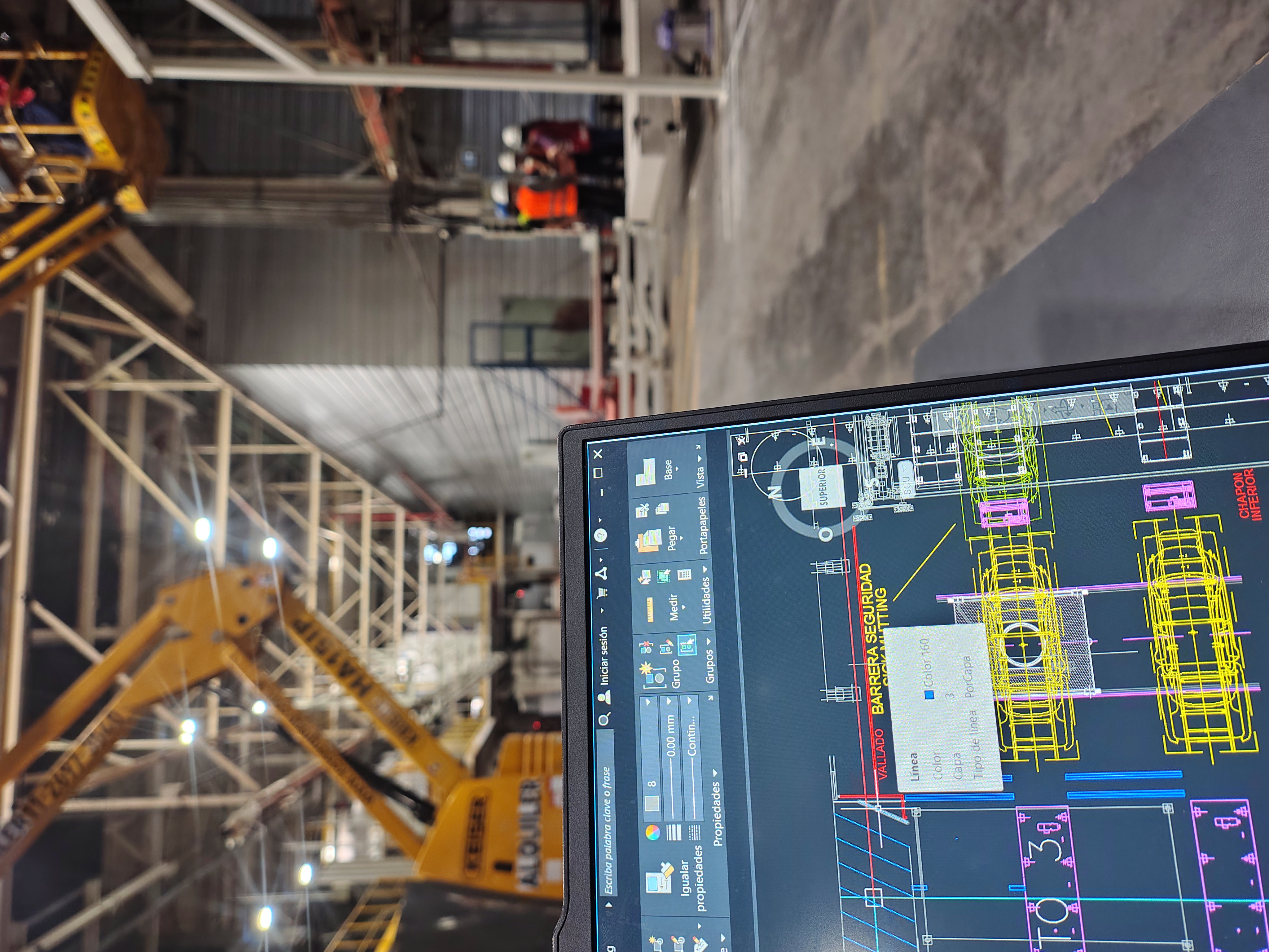Plano técnico digital frente a una planta industrial