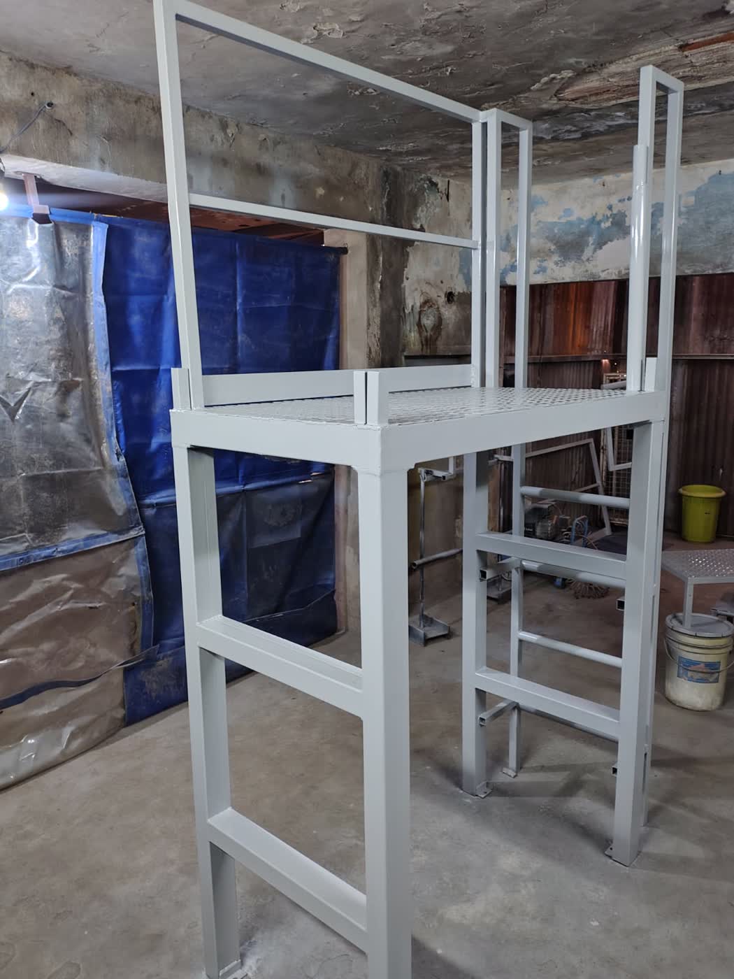 Plataforma metálica de dos niveles con escalera de acceso para planta industrial