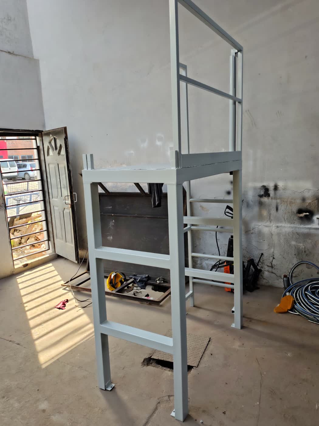 Plataforma elevada con barandas y escalera terminada en taller