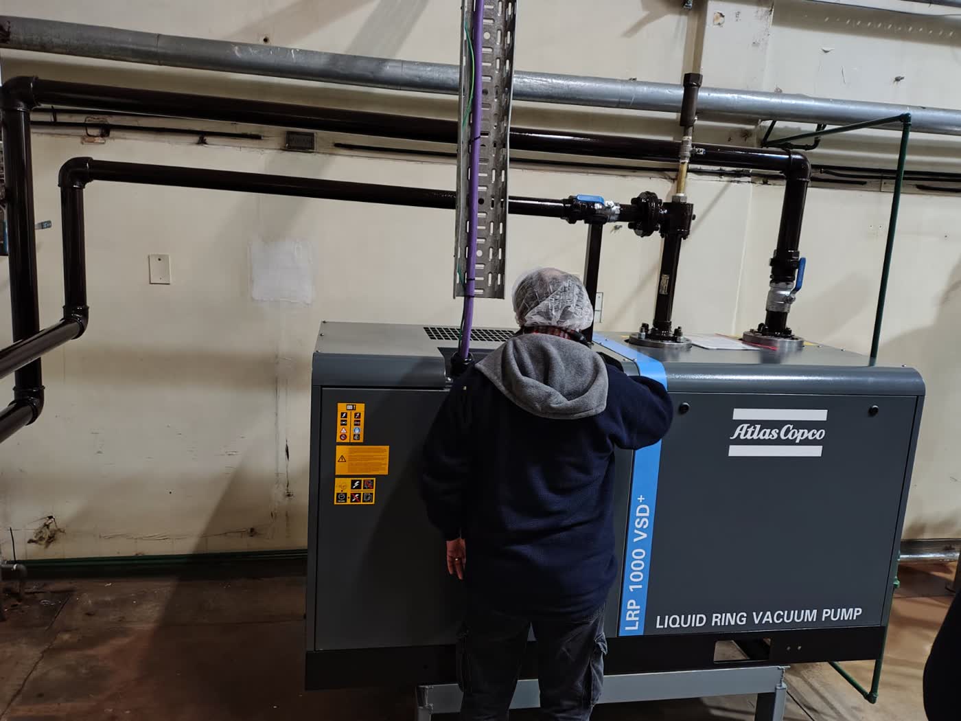 Técnico realizando ajuste en bomba de vacío de anillo líquido